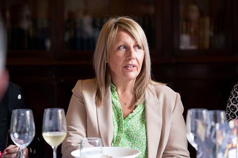 Photograph of RGI Solutions director Sarah Glenn, mid-conversation at the roundtable. She wears a beige blazer with a green floral shirt underneath.